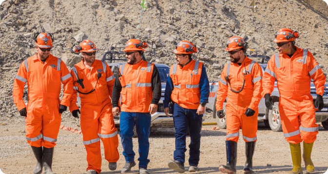 Trabajadores de Globexplore con trajes naranjas de alta visibilidad, destacando nuestro compromiso con la sostenibilidad a través de prácticas respetuosas con el medio ambiente.